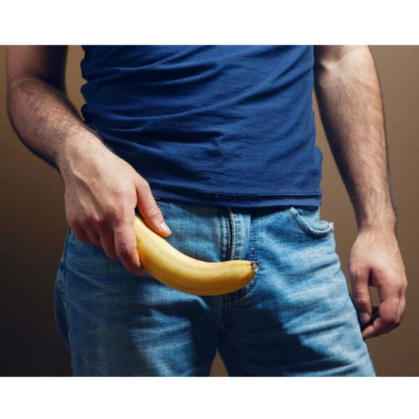Homem segurando uma banana simulando um pênis